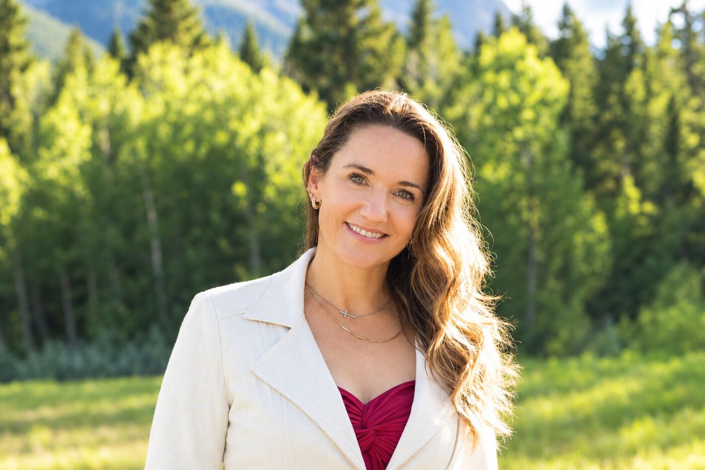 Julia McElgunn smiling outdoors among aspen trees