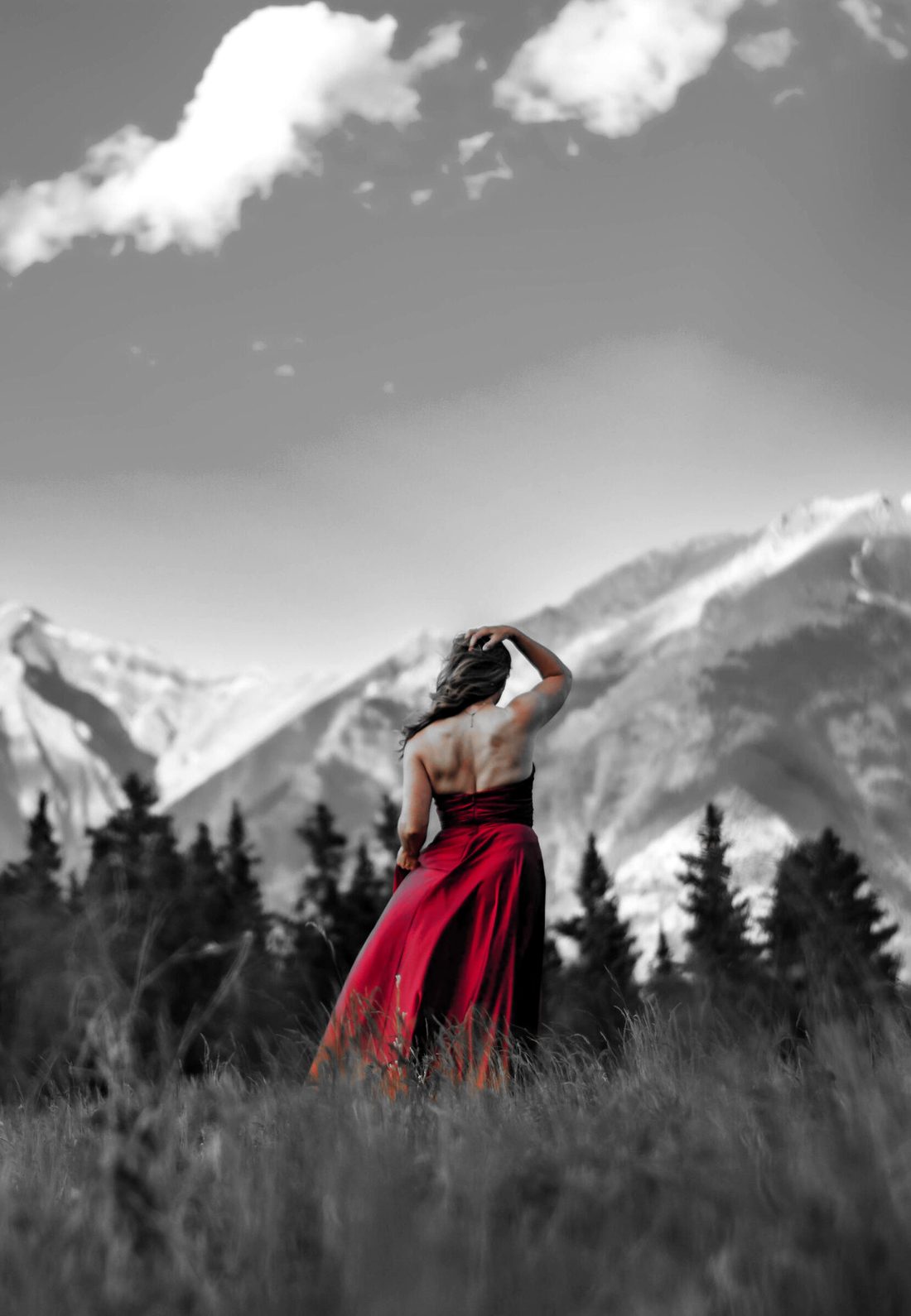 Julia McElgunn in a red gown in a mountain meadow in the Canadian Rockies